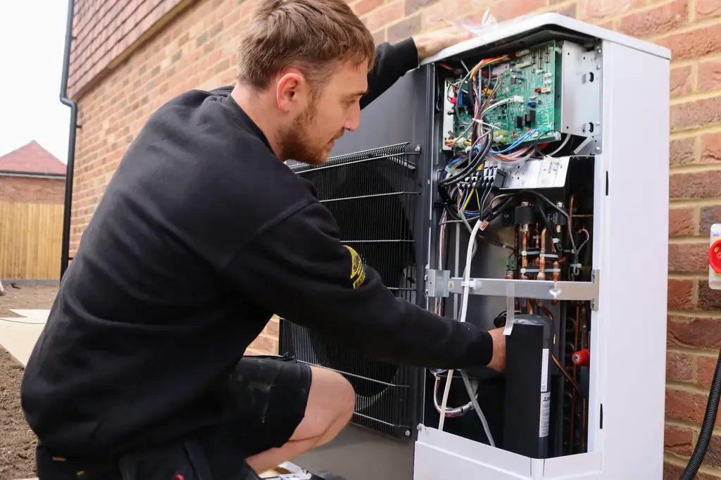 A Phoenix engineer commissioning an air source heat pump at a home in Kent