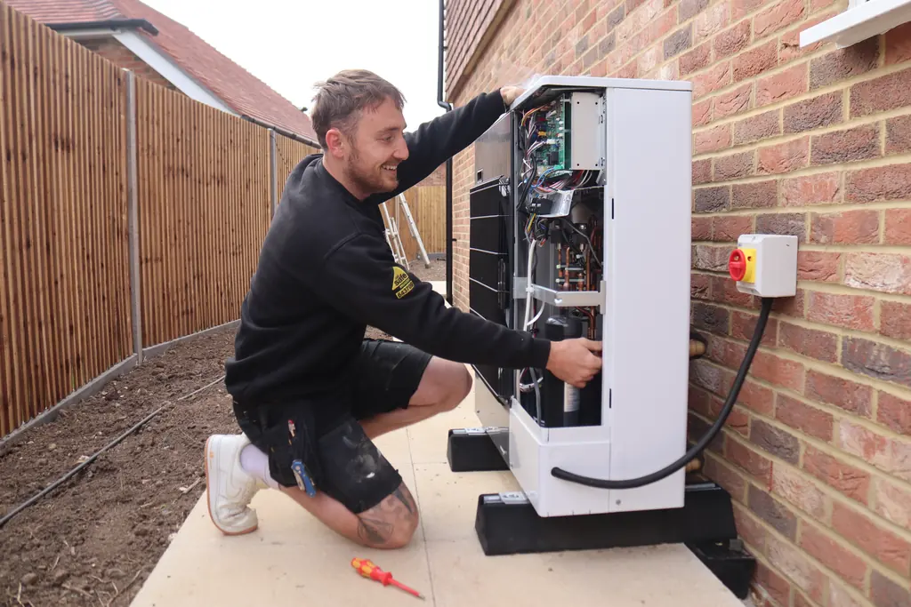 A Phoenix engineer working on an air source heat pump