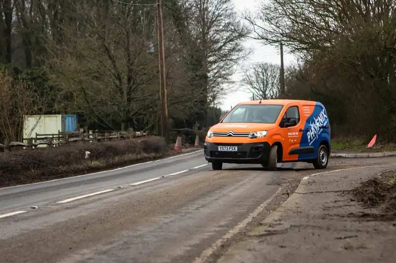 Orange and blue Phoenix Plumbing & Heating van driving along a Kent country road